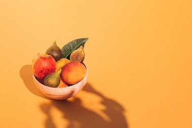 Kayısılar ve incirler turuncu arka planda. Minimum gıda konsepti. Boşluğu kopyala.