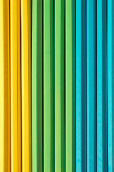 Colorful background made of wooden pencils. Top view with copy space. Flat lay.  Rainbow backdrop.