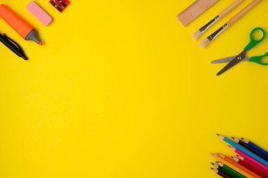 Sarı arka planda kırtasiye aksesuarı. Okul malzemeleri, kalemler, makas, fırça ve sol tarafında fotokopi alanı olan tahta cetvel. Okul konseptine dönelim..