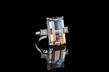 Siyah arka planda topaz değerli taşları olan güzel altın bir yüzük.