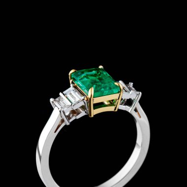 Altından yapılmış güzel bir yüzük, değerli taşlar zümrüt ve yakın plan siyah bir zümrüt.