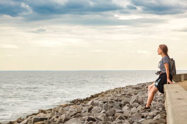 Mavi gökyüzü ve bulutlarla denizdeki güzel kız
