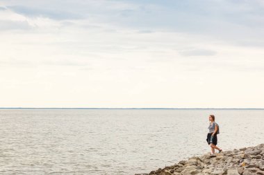 Mavi gökyüzü ve bulutlarla denizdeki güzel kız