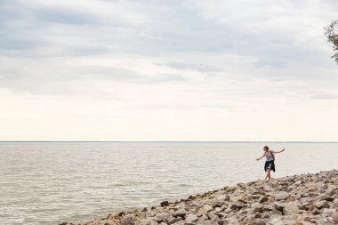 Mavi gökyüzü ve bulutlarla denizdeki güzel kız