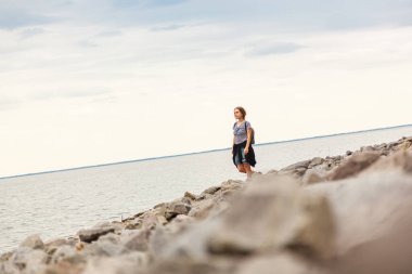 Mavi gökyüzü ve bulutlarla denizdeki güzel kız