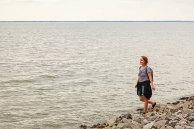 Mavi gökyüzü ve bulutlarla denizdeki güzel kız