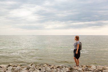 Mavi gökyüzü ve bulutlarla denizdeki güzel kız