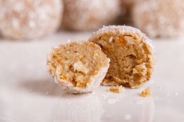 Siyah arka planda beyaz tabakta hindistan cevizli güzel tatlılar.