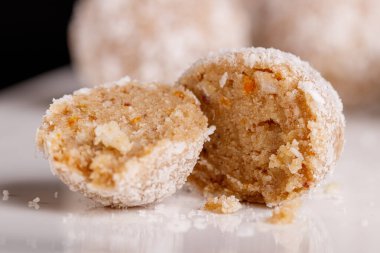 Siyah arka planda beyaz tabakta hindistan cevizli güzel tatlılar.