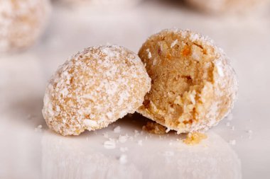 Siyah arka planda beyaz tabakta hindistan cevizli güzel tatlılar.