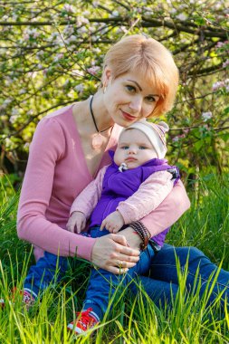 Çiçek açan bir parkta kollarında güzel bir kız.