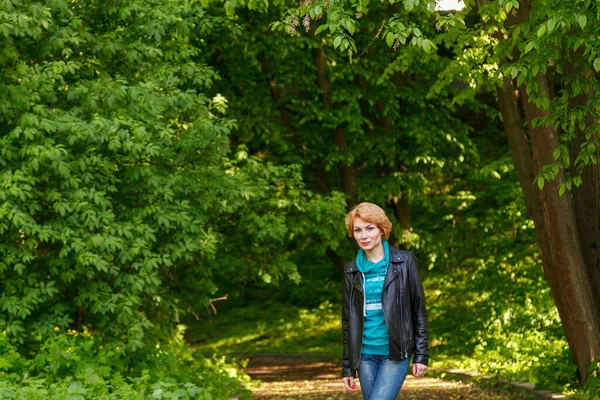 Güzel kız yaz parkında yürüyor. Yakın plan.