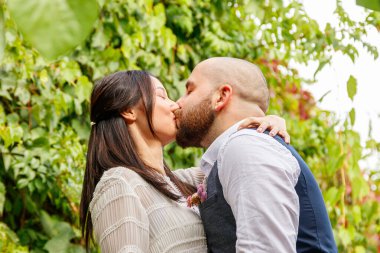 Çiçekli yakışıklı adam nişanlısını öpüyor.