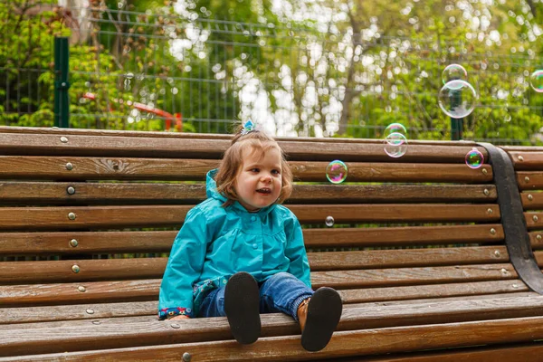 Portrait Little Girl Park Bench Catches Soap Bubbles Close — Stockfoto