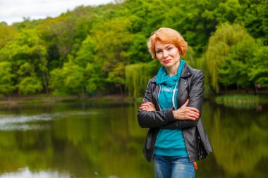 Parktaki güzel kız göl parkının arka planında yakın planda.