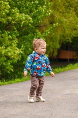 Parktaki yakışıklı çocuk gölün arka planında. Parkta yakın planda.