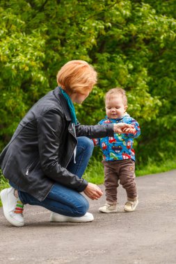 Parkta bir çocukla güzel bir kız gölün arka planında yakın planda.