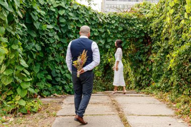 Çiçekli yakışıklı adam nişanlısının yanına gider.