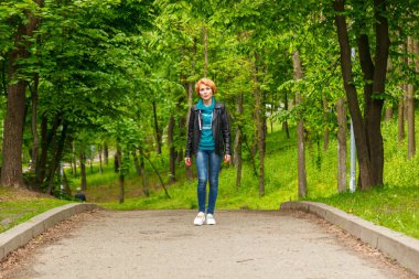 Güzel kız yaz parkında yürüyor. Yakın plan.