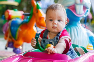 Eğlence gezisi makinesine binen küçük yakışıklı çocuk.