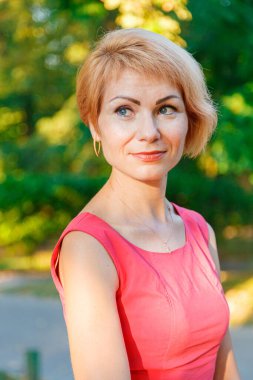 Parkta kırmızı elbiseli güzel bir kız.