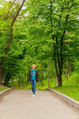Güzel kız yaz parkında yürüyor. Yakın plan.