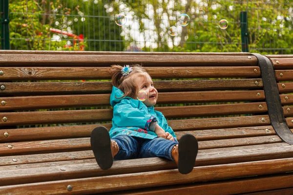 Portrait Little Girl Park Bench Catches Soap Bubbles Close — Stockfoto