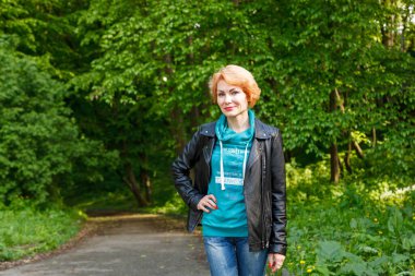 Güzel kız yaz parkında yürüyor. Yakın plan.