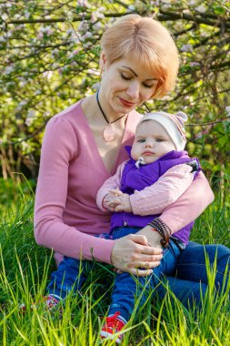 Çiçek açan bir parkta kollarında güzel bir kız.