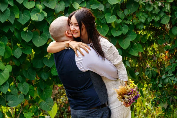 Çiçekli yakışıklı adam nişanlısını öpüyor.