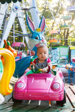 Eğlence gezisi makinesine binen küçük yakışıklı çocuk.