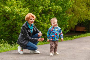 Parkta bir çocukla güzel bir kız gölün arka planında yakın planda.