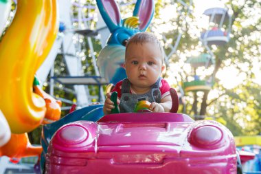 Eğlence gezisi makinesine binen küçük yakışıklı çocuk.