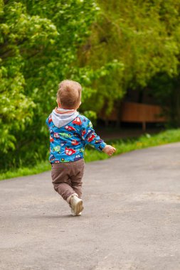 Parktaki yakışıklı çocuk gölün arka planında. Parkta yakın planda.