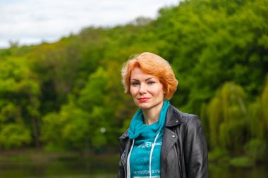 Parktaki güzel kız göl parkının arka planında yakın planda.