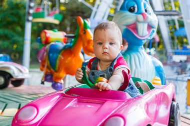 Eğlence gezisi makinesine binen küçük yakışıklı çocuk.