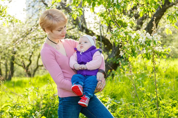 Çiçek açan bir parkta kollarında güzel bir kız.