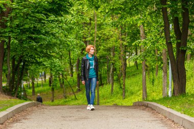 Güzel kız yaz parkında yürüyor. Yakın plan.