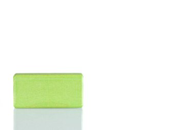 Wooden cube of green color on a white background close up