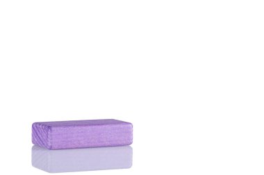 Wooden cube of purple color on a white background close up