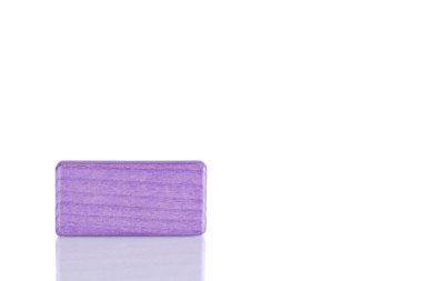 Wooden cube of purple color on a white background close up