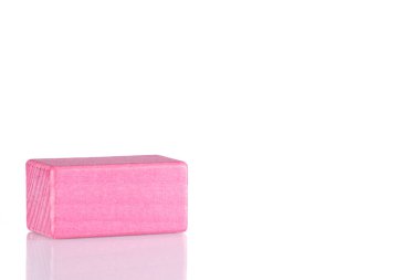 Wooden cube of pink color on a white background close-up