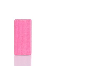 Wooden cube of pink color on a white background close-up