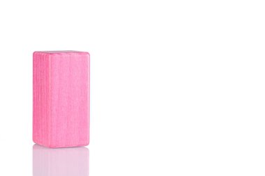 Wooden cube of pink color on a white background close-up