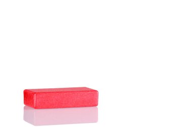 Wooden cube of red color on a white background close up
