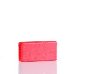 Wooden cube of red color on a white background close up
