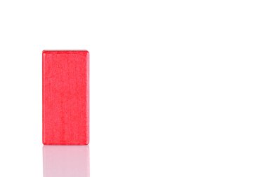Wooden cube of red color on a white background close up