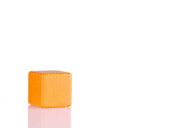 Wooden cube of orange color on a white background close-up