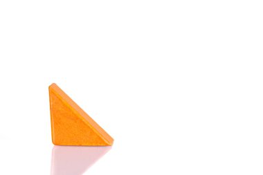 Wooden triangle orange colors on a white background close-up