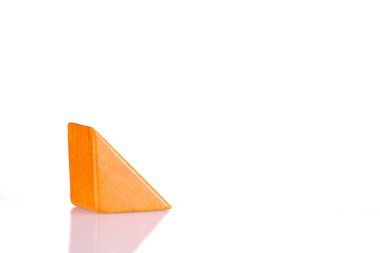 Wooden triangle orange colors on a white background close-up
